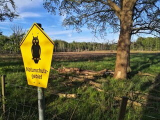 Yellow sign with owl depiction indicating nature reserve zone in nature