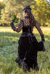 A woman in black with a bouquet of flowers goes into the distance