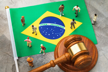 Judge gavel on the background of the flag of Brazil and plastic toy men, the concept of the trial...