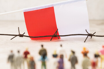 Poland flag, barbed wire and plastic toy men, illegal migration concept