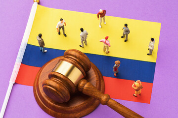 The judicial hammer, the flag of Colombia and toy plastic men on a colored background, the concept...