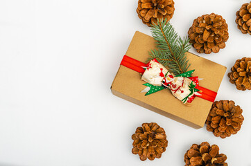 Christmas gift box with pine cones with copy space on white background