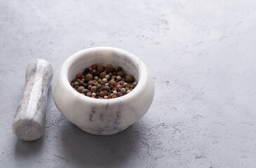 Spices in a mortar, stone mortar, and pestle, cooking tool on gray background.