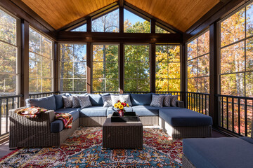 Cozy screened porch with contemporary furniture and flower bouquet in a vase, autumn leaves and...
