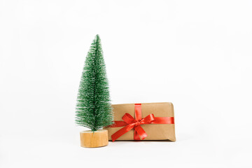 Green tree and gift box wrapped in kraft paper and red ribbon. Items are isolated on a white background.
Isolate. preparation for christmas and new year. Christmas tree and gift. 