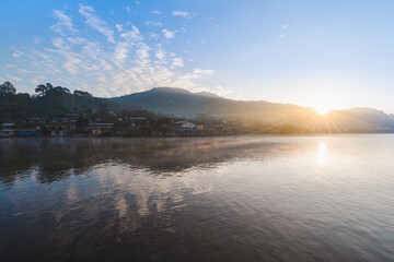 fog rising on the lake view in the morning sunrise scene with reflection of Ban Rak Thai village in Mae Hong Son, Thailand.  
