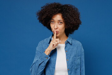 Fototapeta na wymiar Young secret happy black woman in casual clothes shirt white t-shirt say hush be quiet with finger on lips shhh gesture isolated on plain dark blue background studio portrait People lifestyle concept