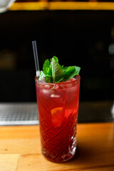 red grapefruit cocktail with mint on wooden bar background