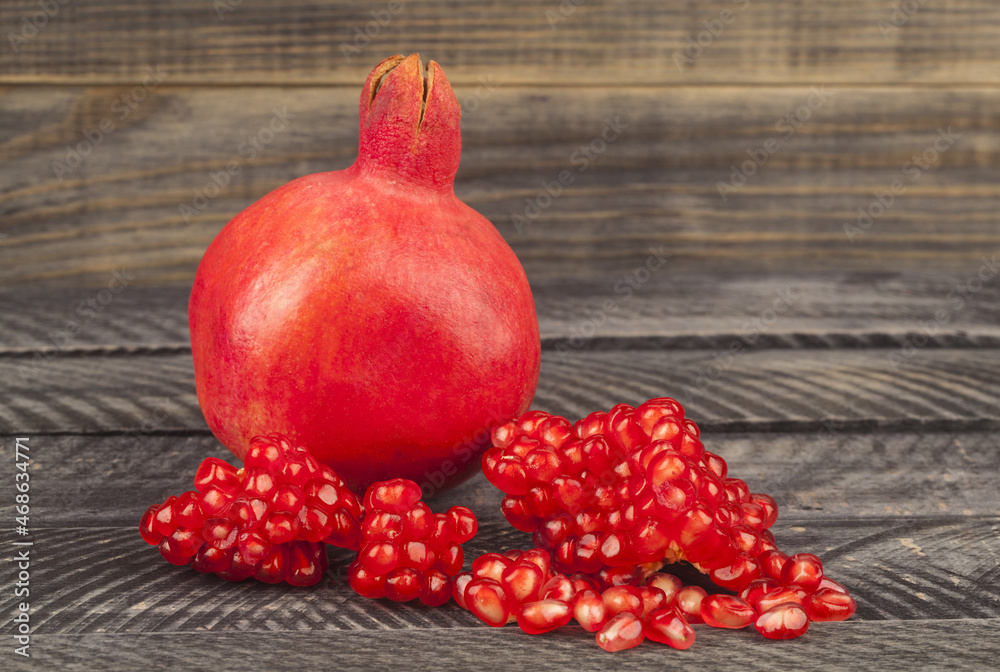 Poster red pomegranate on wooden background.