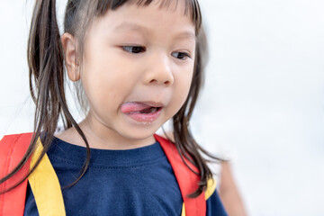 Asian girl 3-year-old use her tongue Lick the milk stains on the lips, with white background, to children and drink milk concept.