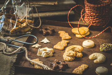 Christmas cookies on a rusty tray with red ribbon, preparation for christmas gifts, vertical