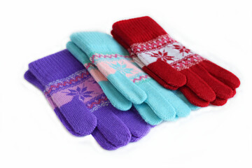 Multicolored knitted gloves on a white background.
