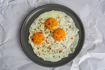 scrambled eggs with spices on a gray plate top view