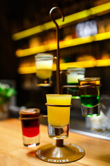 set of cocktails in shots on bright barcounter