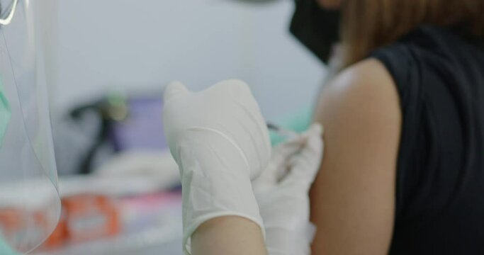 Close Up hand doctor wearing gloves use syringe to prevent COVID 19 on citizens arm. receiving free vaccinations in Vaccine Station. Immunization against all types of viruses. Concept good health care
