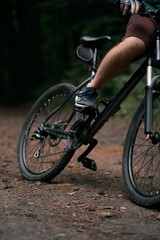 Cross country cycling in the woods. Close up of mountain bike and rider's legs. Extreme braking on the forest trails