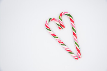 Red candy cane striped in Christmas colours hearts on a white background