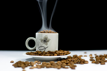 coffee cup and grains of coffee on white table