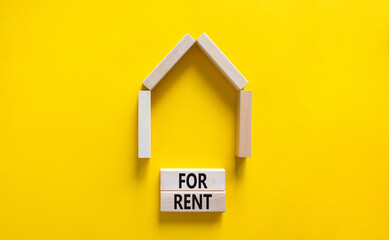 Fototapeta na wymiar House for rent symbol. Concept words 'For rent' on wooden blocks near miniature house. Beautiful yellow background, copy space. Business and house for rent concept.