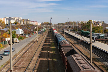 Fototapeta na wymiar Freight cars and railway tracks go into the distance at a railway station on an autumn sunny day