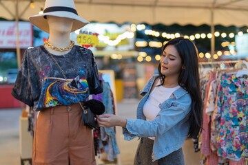 Obraz premium Asian woman shopping in a random night market in Bangkok, Thailand 