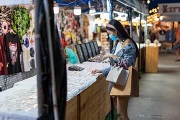Obraz premium Asian woman shopping in a random night market in Bangkok, Thailand 