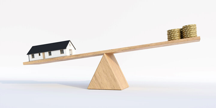 House balance against money on a wooden scale
