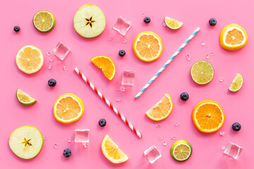 Slices citrus fruits and berries with cocktail tube for fresh juice