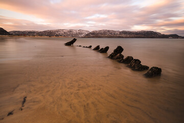 Sandy beach red sunset with stones in the foreground Seascape