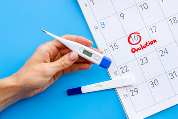 Calendar with hand holding ovulation home test