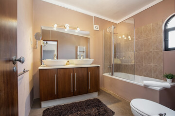 Modern traditional bath, with toilet, bathtub, ceramic tiles all around. With drying, towel,