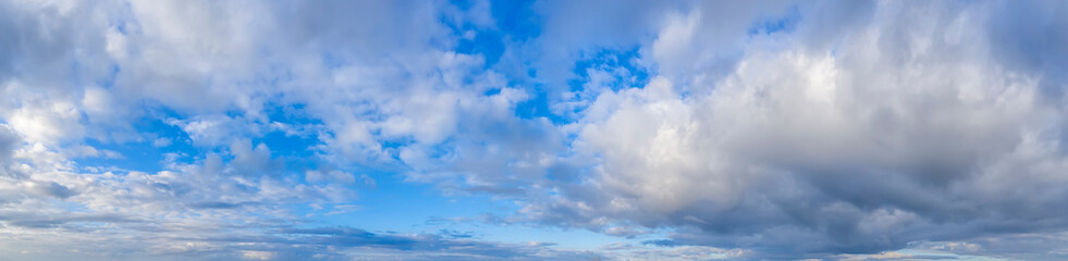 Panoramic view of blue sky with fluffy clouds.