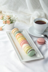 French colorful macarons dessert and cup of coffee on the table