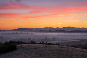 Misty sunrise on the meadow and the first frost