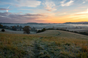 Misty sunrise on the meadow and the first frost