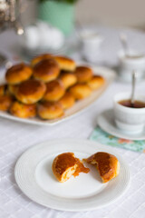 Russian traditional teaparty with samovar and pies or pirozhki with apple jam on white platter on white tablecloth 