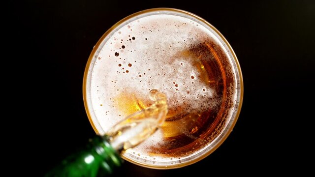 Super slow motion of macro shot of pouring beer drink, top view. Filmed on high speed cinema camera, 1000 fps.