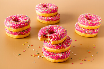 Group of pink frosted donuts with colorful sprinkles