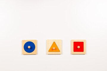 Colorful wooden Montessori sensorial material learning educational toys on white background. Geometric shape sorting board toys for baby kids. Top view