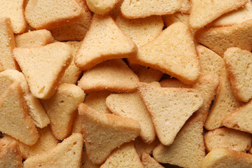 Heap of crispy rusks as background, top view