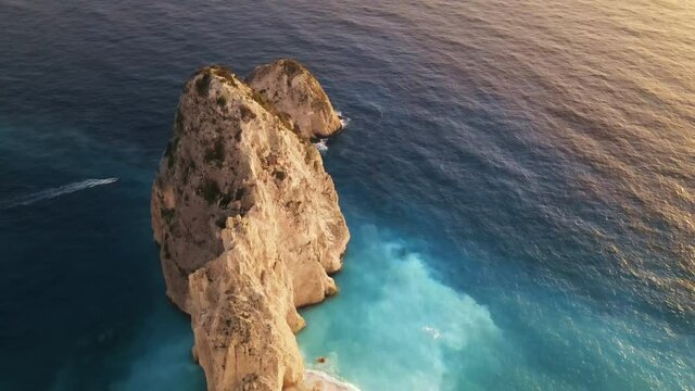 Aerial drone view of the Ionian Sea coast of Zakynthos, Greece. Rocky ridge, floating boat, blue water. Sunset