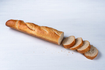 freshly baked baguette and slices on white background, top view