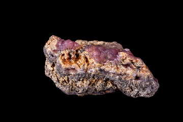 Macro pink Smithsonite mineral stone on microcline on black background