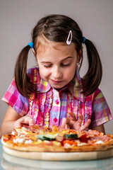 Young hungry girl taking slices of delicious pizza. Vertical image.