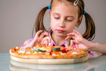 Beautiful young girl eating a slice of pizza