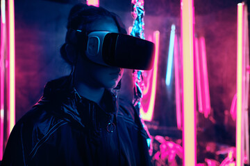 Teenager wearing virtual reality glasses in neon light