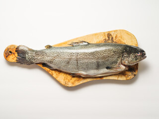 One fresh fish on a cutting board on a white background. Minimalism. There are no people in the photo. Cooking, preparation of fish and seafood dishes, advertising, restaurant, hotel cafe, deli.