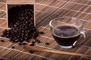 Coffee cup and coffee beans on brown wood table background