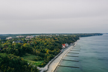 Panoramic aerial view of the Baltic Sea coast and the promenade in the resort town of Svetlogorsk, beach, Waves breaking on breakwaters, Old wooden ridges. Kaliningrad region.