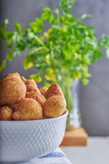 Buñuelos de bacalao con perejil caseros servidos con una fuente de porcelana.
